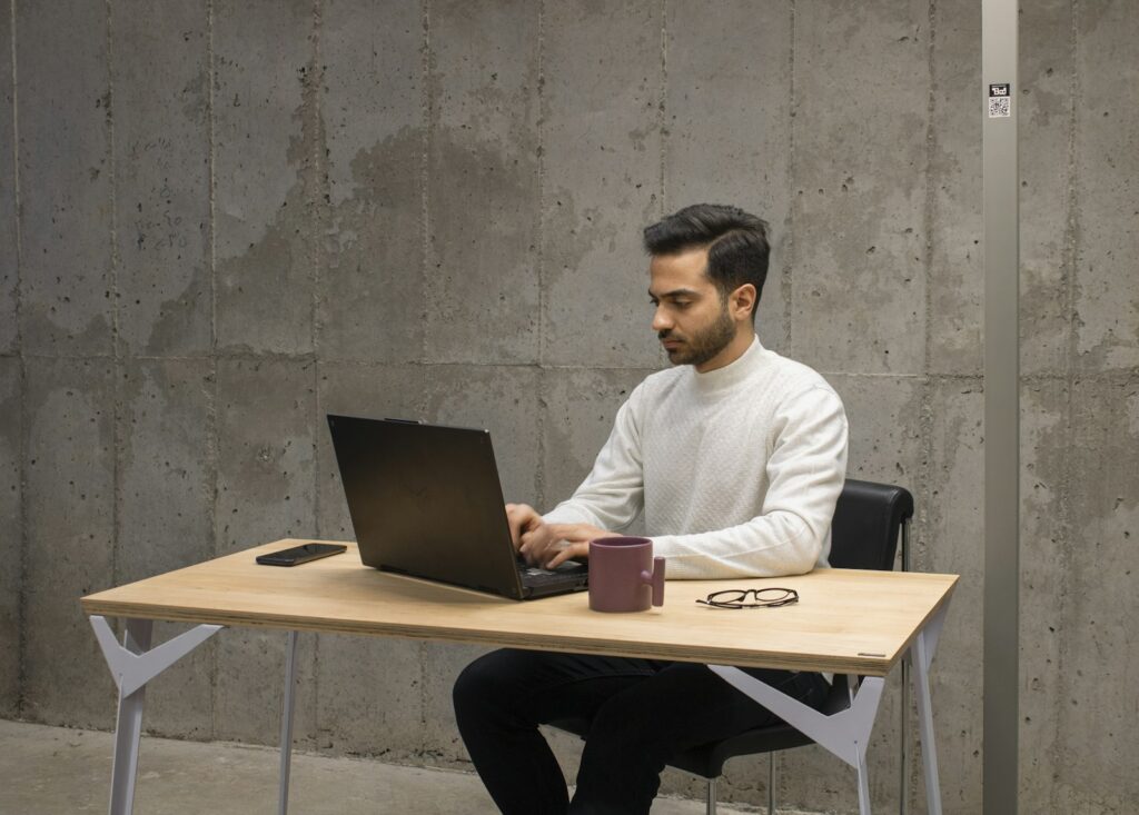 Mann tippt an einem Laptop am Schreibtisch, ein typischer Arbeitsplatz zum Anpassen der Tastatur