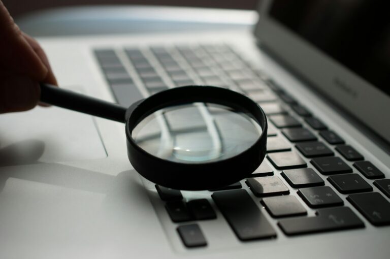 crew cloudysocial com – Lupe über einer Laptop-Tastatur