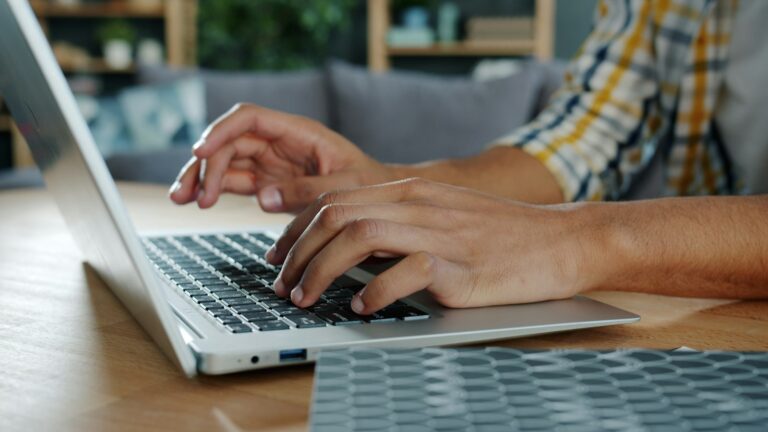 iCloud Mail in Outlook einrichten: neues und klassisches Outlook iCloud Mail in Outlook einrichten – Hände tippen auf einer Laptop-Tastatur
