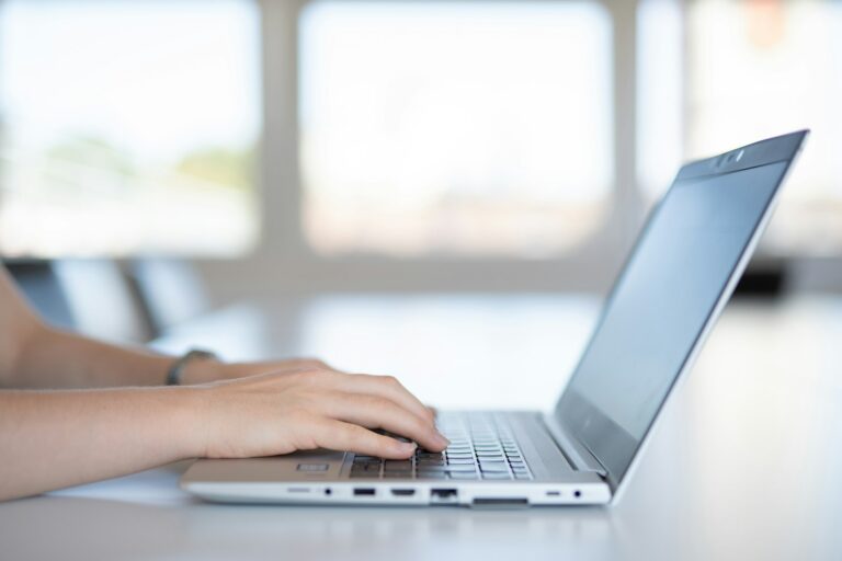 LogicalShout – Hände tippen auf einem Laptop am hellen Schreibtisch