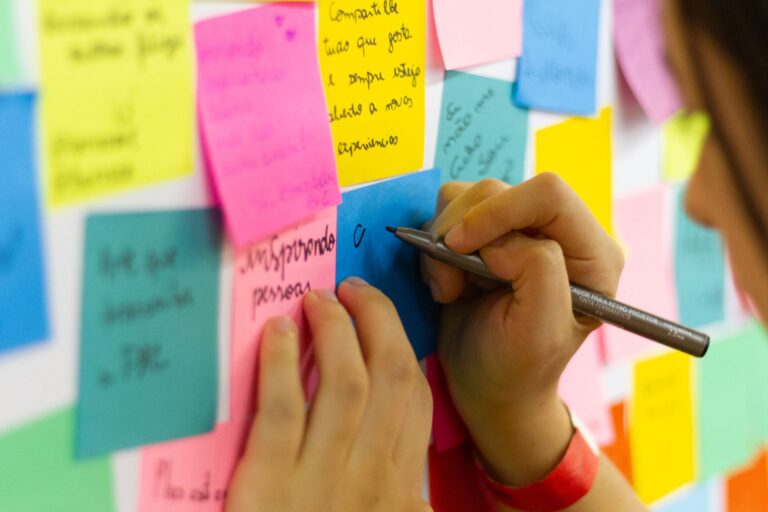 Online-Whiteboards – Hände beschriften bunte Haftnotizen beim Brainstorming