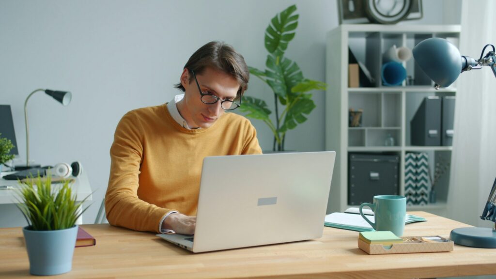 Mann im Homeoffice arbeitet konzentriert an einem Laptop