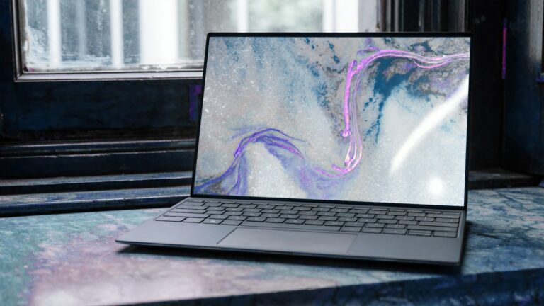 Widgets.exe Windows 11 – aufgeklappter Laptop mit abstraktem Hintergrundbild am Fenster